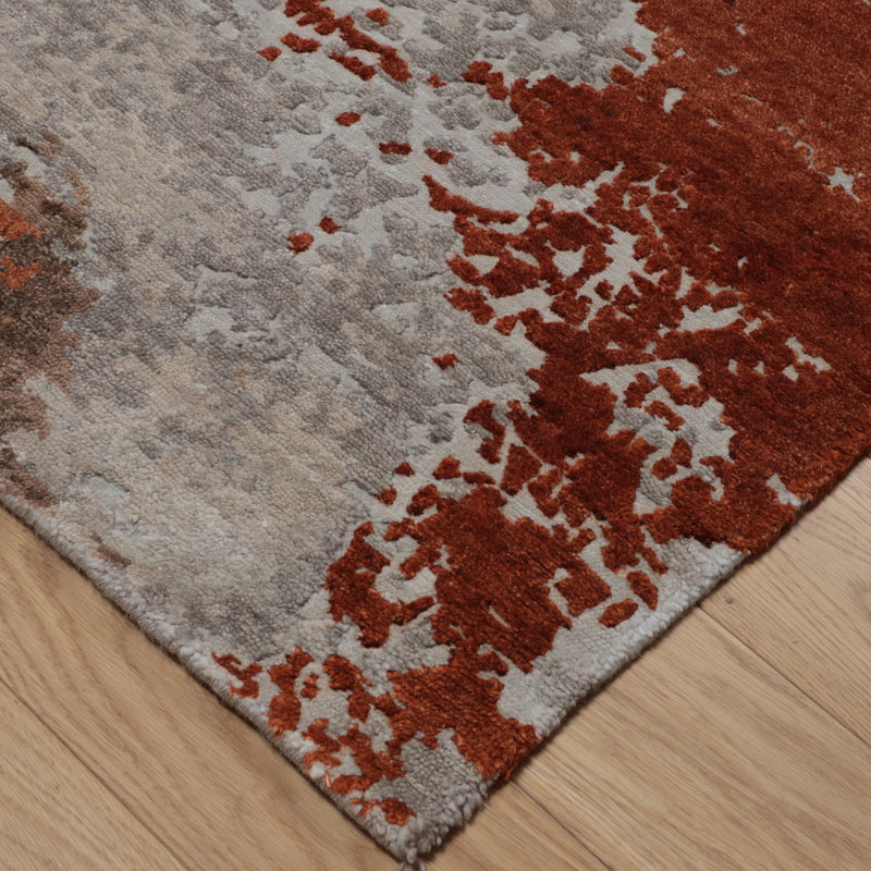 Beige and rust abstract wool area rug corner with high-contrast texture
