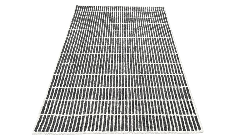Charcoal and ivory hand-tufted wool area rug with vertical stripe grid pattern, wide view.