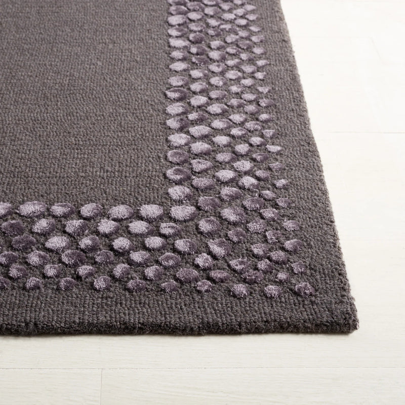 Ash grey rug edge with raised pebble tuft details along border