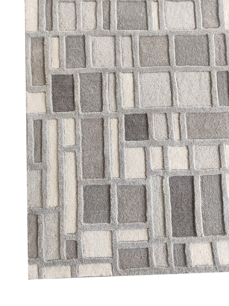 Close-up of grey and ivory geometric block-pattern hand-tufted wool rug pile