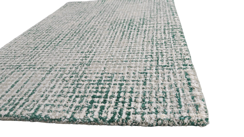 Hand-tufted wool rug in ivory and emerald green, textured loop pile with visible thickness