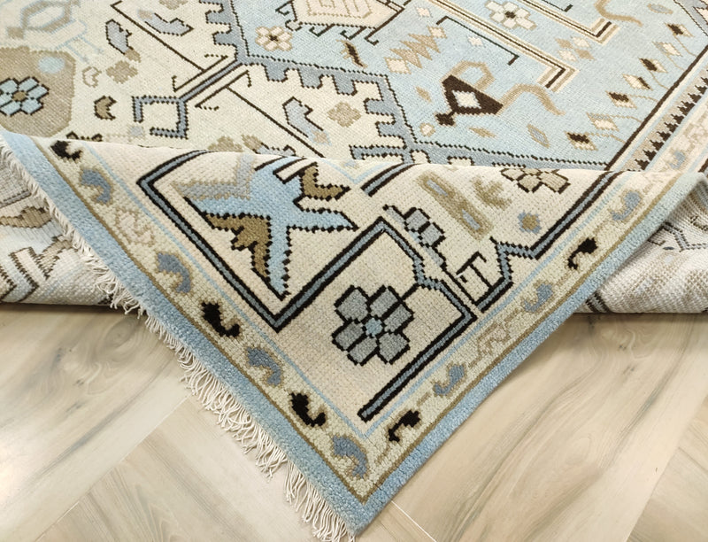 Corner of vintage area rug with fringed edges and blue geometric motifs