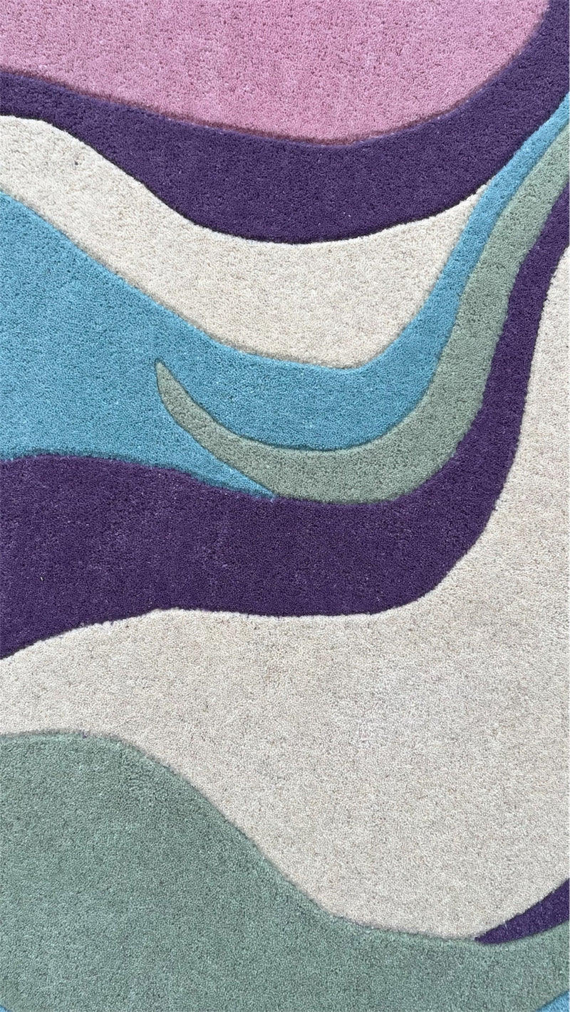 Close-up of Serpentine hand-tufted wool rug with soft pastel colors and textured pile