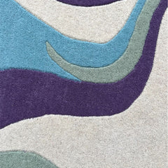Close-up of Serpentine hand-tufted wool rug with soft pastel colors and textured pile