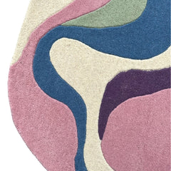 Serpentine irregular area rug featuring pink, blue, green, plum and ivory abstract shapes