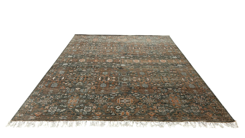 Hand-knotted wool rug in charcoal and rust with short fringe and ornate geometric pattern