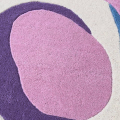 Video of Serpentine pastel irregular hand-tufted wool rug featuring flowing abstract curves in soft pink, blue, green, plum and ivory.