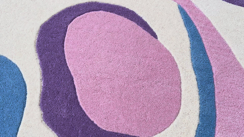 Video of Serpentine pastel irregular hand-tufted wool rug featuring flowing abstract curves in soft pink, blue, green, plum and ivory.